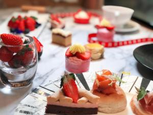 a table topped with desserts on plates with strawberries at Grand Millennium Shanghai HongQiao in Shanghai