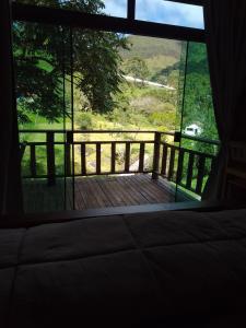 a room with a view of a wooden deck with a window at chale opucv in Gonçalves