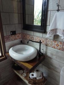 ein Badezimmer mit einem weißen Waschbecken und einem Spiegel in der Unterkunft chale opucv in Gonçalves