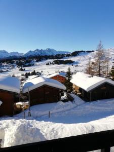 una ciudad cubierta de nieve con edificios en les saisies ;loue a la semaine, en Hauteluce