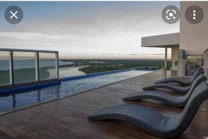 a pool on a building with chairs on the deck at Bugan - Paiva Home Stay A&F in Recife