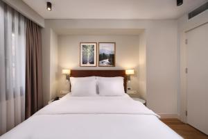 a bedroom with a large white bed with two lamps at Suadhan Hotel in Istanbul