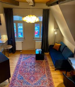 a living room with a blue couch and a rug at Apartmenthaus am Dom Maisonette mit Parkplatz in Zwickau