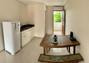 uma cozinha com uma mesa de madeira e um frigorífico em Loft Jaques em Palhoça
