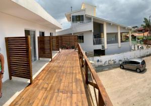 una terraza de madera frente a una casa en Loft Jaques, en Palhoça