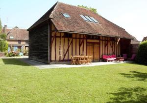 ein Haus mit einem Tisch und Stühlen im Hof in der Unterkunft Gîtes Famille En Othe in Bouilly