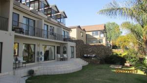 a large apartment building with a yard in front of it at La Dolce Vita Guest House in Hartbeespoort