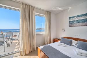 a bedroom with a bed and a balcony with the ocean at Sunset Split Rooms in Podstrana