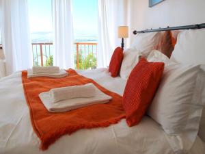 a white bed with two towels and pillows on it at La Dolce Vita Guest House in Hartbeespoort