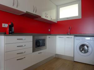a kitchen with white cabinets and a washing machine at Rentalmar Navarra family suites in Salou