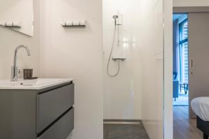 a white bathroom with a sink and a shower at Dutchen Suitelodges Gooilanden in Loosdrecht +81 photos