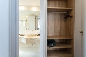 a bathroom with a sink and a mirror at H4 La Residence Paulista in Sao Paulo