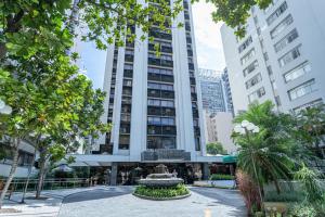 ein hohes Gebäude mit einem Brunnen davor in der Unterkunft H4 La Residence Paulista in São Paulo