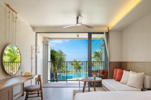 a living room with a bed and a view of the ocean at U Samui in Bangrak Beach