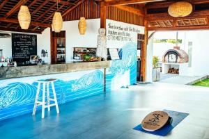 ein Restaurant mit einer Bar mit Theke und Hocker in der Unterkunft Rapture Surfcamps Green Bowl in Ungasan