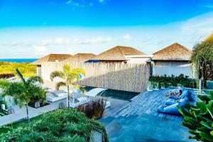 eine Villa mit einem Pool am Meer in der Unterkunft Rapture Surfcamps Green Bowl in Ungasan