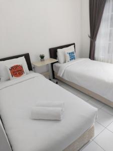 um quarto com duas camas e uma mesa em Tamadara Guesthouse Jogja em Seturan