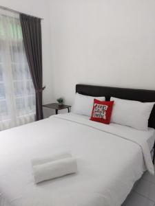 Seturan的住宿－Tamadara Guesthouse Jogja，一张白色的大床,上面有红色枕头