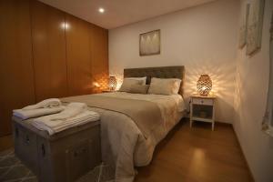 a bedroom with a large bed and two lamps at Casas Martainha in Sernancelhe