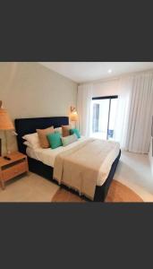 a bedroom with a large bed with pillows and a window at Eastern Blue Beachfront Luxury Apartment in Poste Lafayette
