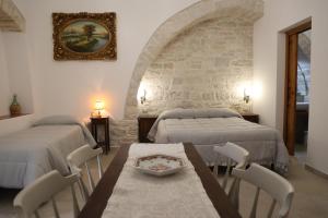 een slaapkamer met 2 bedden en een tafel en stoelen bij Antico Monastero in Bitonto