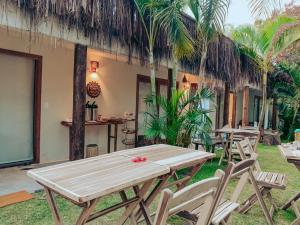 a wooden table and chairs in front of a building at Pousada Jaboticaba Caraíva in Caraíva