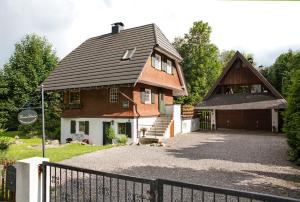 a house with a gambrel roof and a driveway at Chalet am Birkenhain in Hinterzarten