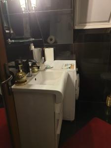 y baño con lavabo blanco y espejo. en Camere LUX Telecabina Busteni, en Buşteni