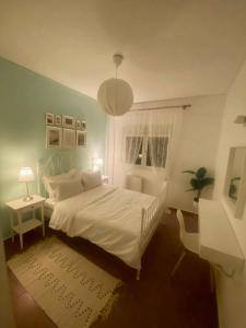 a bedroom with a white bed and a window at SnD Rentals -Boutique apartments in Kozani