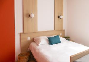 een slaapkamer met een wit bed en een blauw kussen bij Sweetly Isatis Mérignac Hôtel de ville in Mérignac