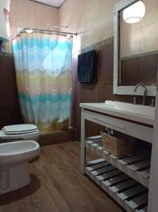 y baño con lavabo, aseo y ducha. en Cabaña La América en Ezeiza