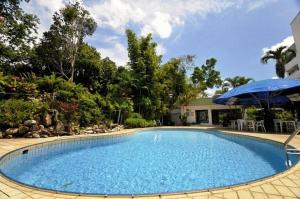 a large blue swimming pool with a blue umbrella at Terrace Hotel in Bandar Seri Begawan