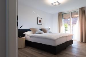 a bedroom with a large bed and a window at Hôtel la Croix Blanche in Posieux