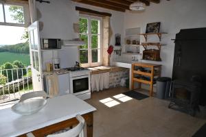 eine Küche mit weißen Geräten und einem großen Fenster in der Unterkunft Maison Machecourt in Champallement