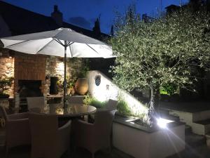 Spring Garden Cottage في ويدبريدج: طاولة مع مظلة في حديقة في الليل +8 صور
