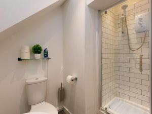 a white bathroom with a toilet and a shower at Flat 1 Castle Street Serviced Apartments in Telford