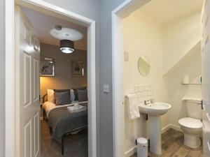 a bathroom with a bed and a sink in a room at Flat 1 Castle Street Serviced Apartments in Telford