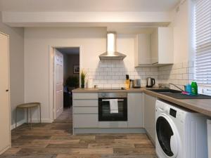a kitchen with a washer and dryer in it at Flat 1 Castle Street Serviced Apartments in Telford