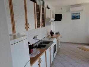 eine Küche mit einer Spüle und einem Herd in der Unterkunft Kuća za odmor Zdravka in Blato