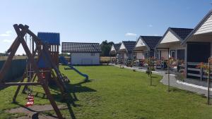 a playground in front of a row of houses at Błękitna Laguna in Rusinowo