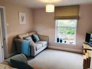 a living room with a couch and a window at Two bedroom house in central Portree in Portree