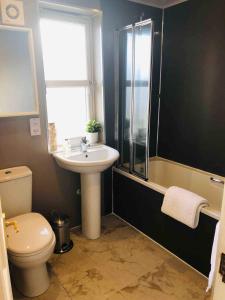 a bathroom with a toilet and a sink and a shower at Two bedroom house in central Portree in Portree