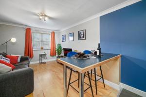 ein Wohnzimmer mit einem Tisch und einem Sofa in der Unterkunft Modern Warwick Apartment, Sleeps 3, Claverdon House in Warwick