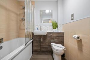 ein Bad mit einem WC, einem Waschbecken und einer Dusche in der Unterkunft Modern Warwick Apartment, Sleeps 3, Claverdon House in Warwick
