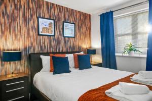 1 dormitorio con 1 cama con cortinas azules y ventana en Modern Warwick Apartment, Sleeps 3, Claverdon House, en Warwick