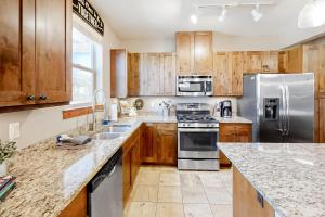 a kitchen with wooden cabinets and stainless steel appliances at Trailhead Lodge 322 in Winter Park