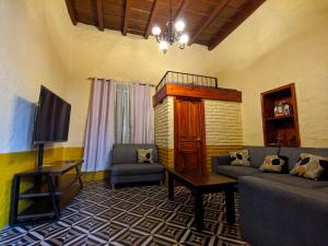 a living room with a couch and a tv at Casa Vieja in Mazamitla