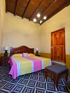 1 dormitorio con 1 cama y 1 silla en Casa Vieja, en Mazamitla