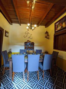 a dining room with a table and blue chairs at Casa Vieja in Mazamitla