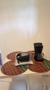 uma mesa com uma máquina de café em cima em Suítes home paraíso no norte em Ilhabela